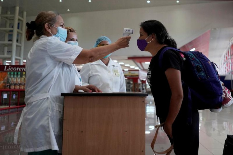 FILE PHOTO: A traveller has her temperature checked at the Jose Marti International Airport amid concerns about the spread of the coronavirus disease (COVID-19), in Havana, Cuba, November 15, 2020. REUTERS/Alexandre Meneghini