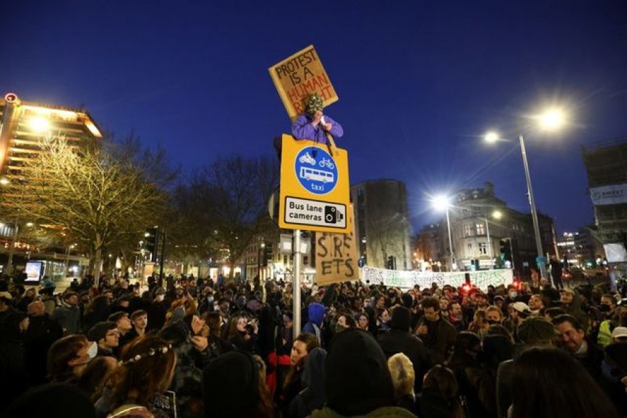 A masked demonstrator holds a placard on top of a post during a "Kill the Bill" protest in Bristol, Britain, April 3, 2021. REUTERS/Henry Nicholls