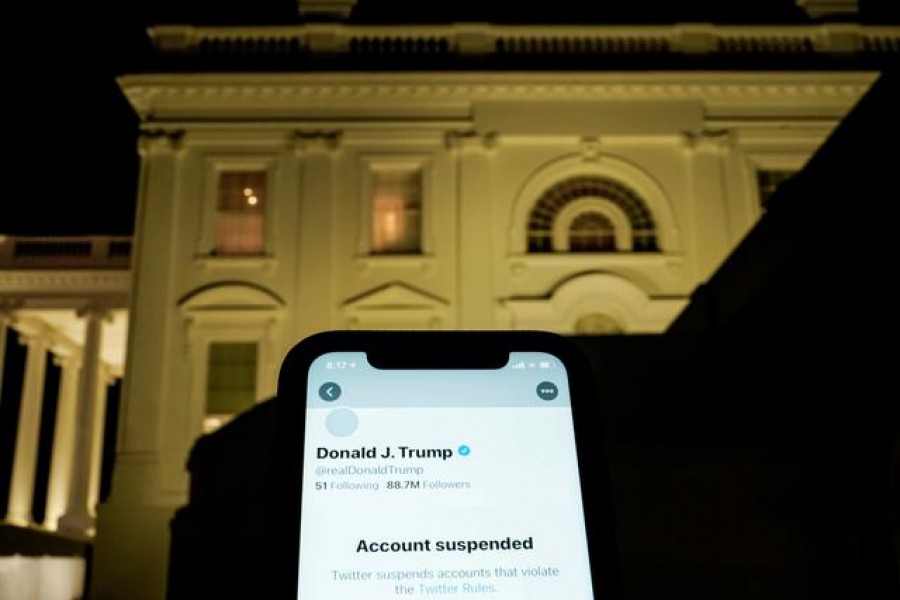 FILE PHOTO: A photo illustration shows the suspended Twitter account of US President Donald Trump on a smartphone and the White House in Washington, US, January 8, 2021. REUTERS/Joshua Roberts/Illustration/File Photo