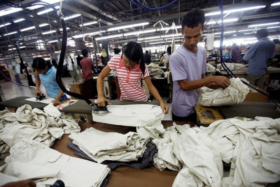 Workers iron and arrange clothing at a garment factory at Hlaing Taryar industrial zone in Yangon, March 10, 2010. Reuters