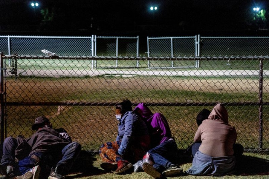 Asylum-seeking migrants' families rest on the ground while waiting to be transported by the US Border Patrols after crossing the Rio Grande River into the United States from Mexico in La Joya, Texas, U.S., April 7, 2021. REUTERS/Go Nakamura/File Photo