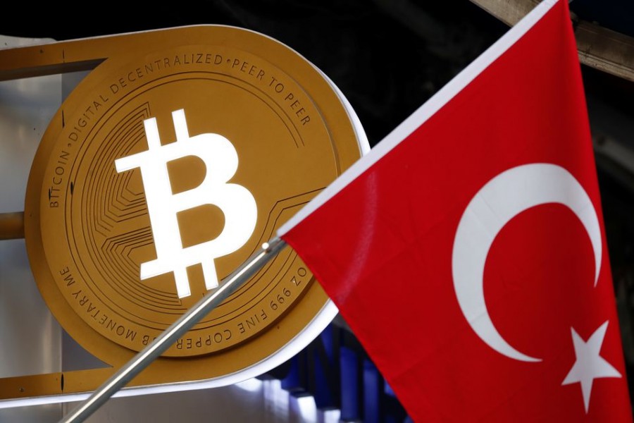 A bitcoin logo is seen next to Turkish flag at a cryptocurrency exchange shop in Istanbul, Turkey April 27, 2021. Picture taken April 27, 2021. REUTERS/Murad Sezer