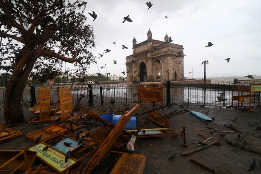 Pigeons fly next to scattered barricades near the Gateway of India monument after heavy winds caused by Cyclone Tauktae, in Mumbai, India, May 18, 2021 — Reuters