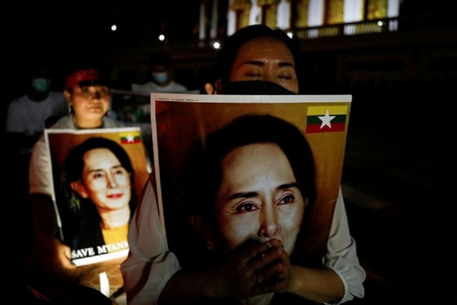 Migrants protesting against the military junta in Myanmar hold pictures of leader Aung San Suu Kyi, during a candlelight vigil at a Buddhist temple in Bangkok, Thailand, March 28, 2021. Reuters