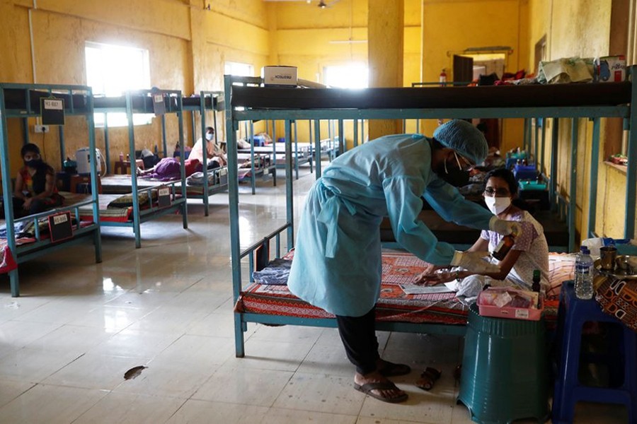 A doctor checks the medicines of a patient suffering from coronavirus disease (Covid-19) inside a classroom turned Covid-19 care facility on the outskirts of Mumbai, India on May 24, 2021