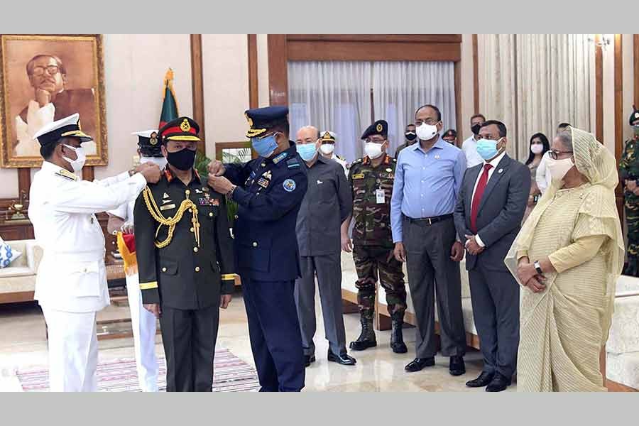 Chief of Naval Staff Admiral M Shaheen Iqbal and Chief of Air Staff Air Marshal Shaikh Abdul Hannan adorn Chief of Army Staff SM Shafiuddin Ahmed with the rank badge of General in the presence of Prime Minister Sheikh Hasina at Ganabhaban on Thursday -PID Photo