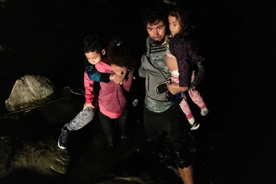 Asylum-seeking migrants' families from Ecuador walk in the water as they arrive to the bank of the Rio Grande river after crossing into the United States from Mexico in Roma, Texas, US, July 7, 2021 — Reuters