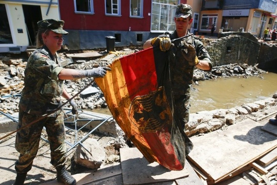 German Bundeswehr soldiers rescue a German national flag as they help to clean up following heavy rainfalls, in Bad Muenstereifel, North Rhine-Westphalia state, Germany, July 21, 2021 — Reuters