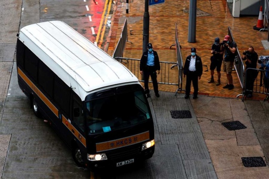 A prison van arrives as police stand guard for Tong Ying-kit's arrival, the first person charged under a new national security law, in Hong Kong, China, July 30, 2021. REUTERS