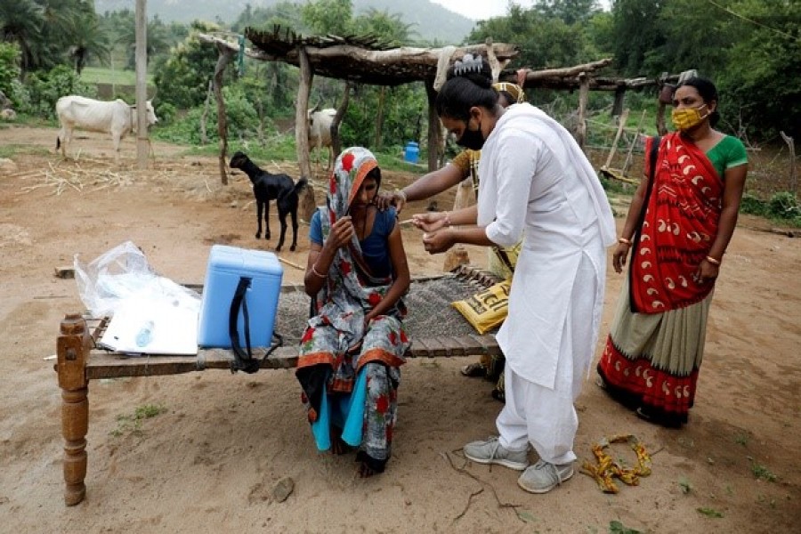 Healthcare worker Jankhana Prajapati gives a dose of the domestically manufactured COVISHIELD vaccine to villager Amiyaben Dabhi during a door-to-door vaccination drive in Banaskantha district in the western state of Gujarat, India, July 23, 2021 — Reuters/Files