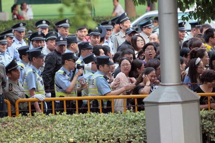 Police officers remove fans standing outside the opening ceremony of the 17th Shanghai International Film Festival, June 14, 2014. REUTERS/Aly Song