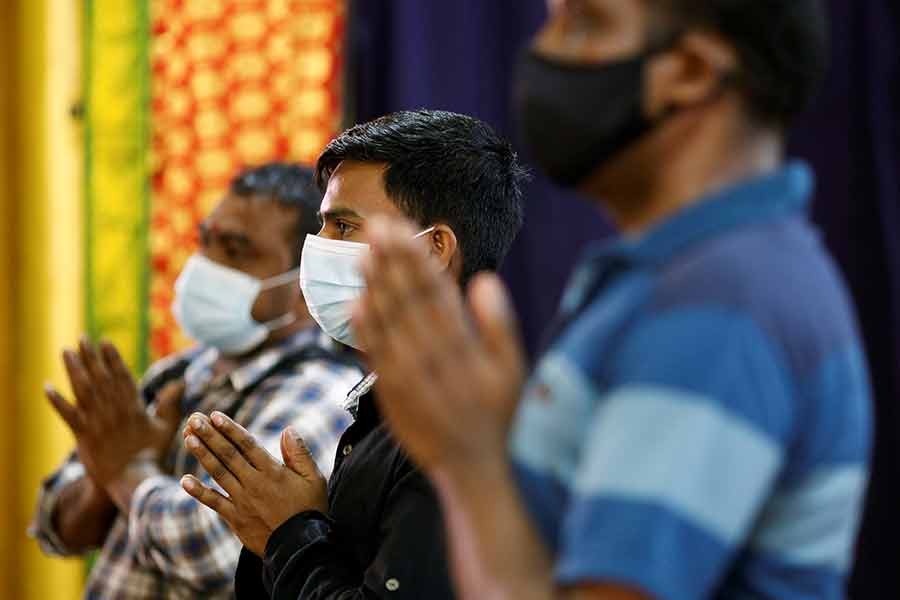 Migrant workers pray at a temple, before enjoying time off at Little India, as part of a pilot programme to allow fully vaccinated migrant workers back to the community after more than a year of movement curbs due to the coronavirus disease (COVID-19) outbreak, in Singapore  on Wednesday –Reuters photo