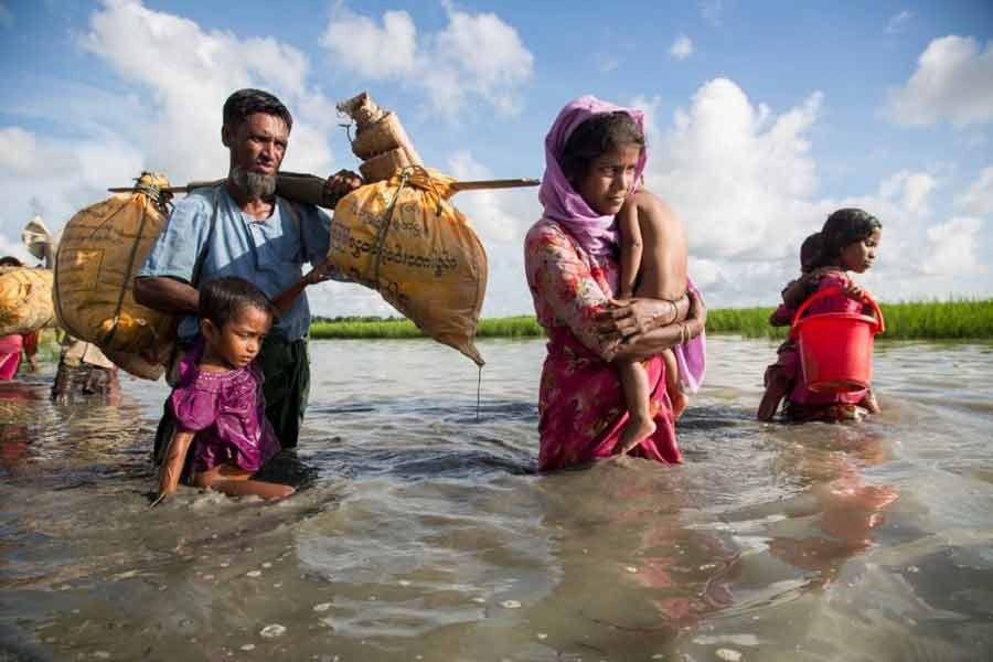 A Rohingya family wades through water crossing the border from Myanmar into Bangladesh.   —UNHCR Photo