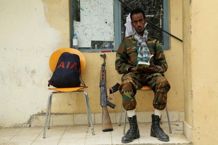 A soldier with the Tigrayan forces reads a book as he guards the headquarters of the Tigrai Mass Media Agency in Mekelle, the capital of Tigray region, Ethiopia, July 7, 2021. REUTERS