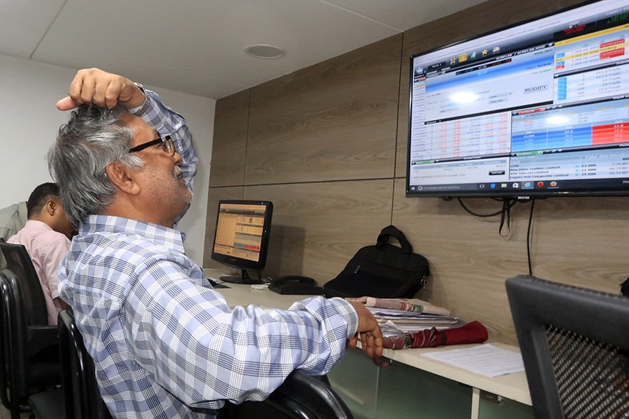 Investors react while monitoring stock price movements on TV and computer screens at a brokerage house in the capital city — FE/Files