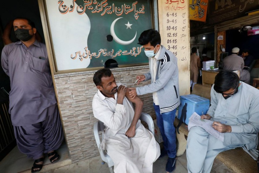 A man receives a dose of the coronavirus disease (COVID-19) vaccine at a market in Karachi, Pakistan, December 16, 2021. REUTERS/Akhtar Soomro