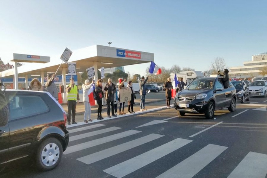People gather as a vehicle convoy with French and Canadian flags passes, in Nantes, France, February 11, 2022 in this still image obtained from a video posted on social media. Photos Souvenir/via REUTERS