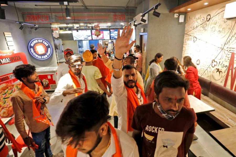 Activists of Bajrang Dal, a Hindu hardline group, shout slogans inside a Pizza Hut food outlet during a protest over their Pakistani partners' tweet in support of Kashmir, in Ahmedabad, India, February 12, 2022 – Reuters/Amit Dave