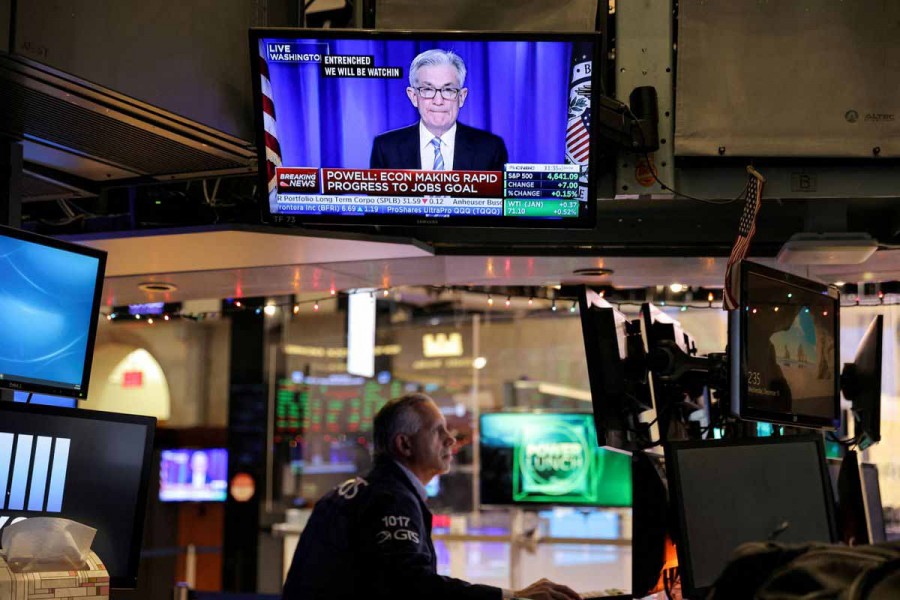 Federal Reserve Chair Jerome Powell is seen delivering remarks on a screen as a trader works on the trading floor at the New York Stock Exchange (NYSE) in Manhattan, New York City, US, December 15, 2021 – Reuters/Andrew Kelly