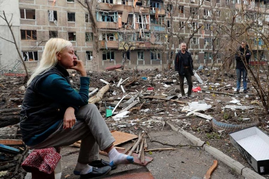 Local resident gather in a courtyard near a block of flats heavily damaged during Ukraine-Russia conflict in the southern port city of Mariupol, Ukraine April 18, 2022 — Reuters
