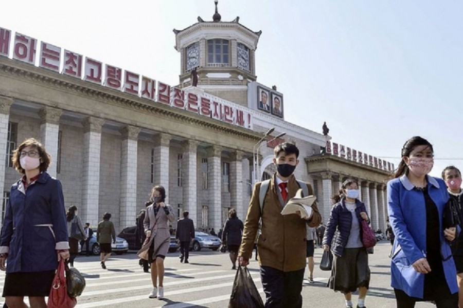 People wearing protective face masks walk amid concerns over the new coronavirus disease (COVID-19) in front of Pyongyang Station in Pyongyang, North Korea April 27, 2020, in this photo released by Kyodo. Mandatory credit Kyodo/via REUTERS