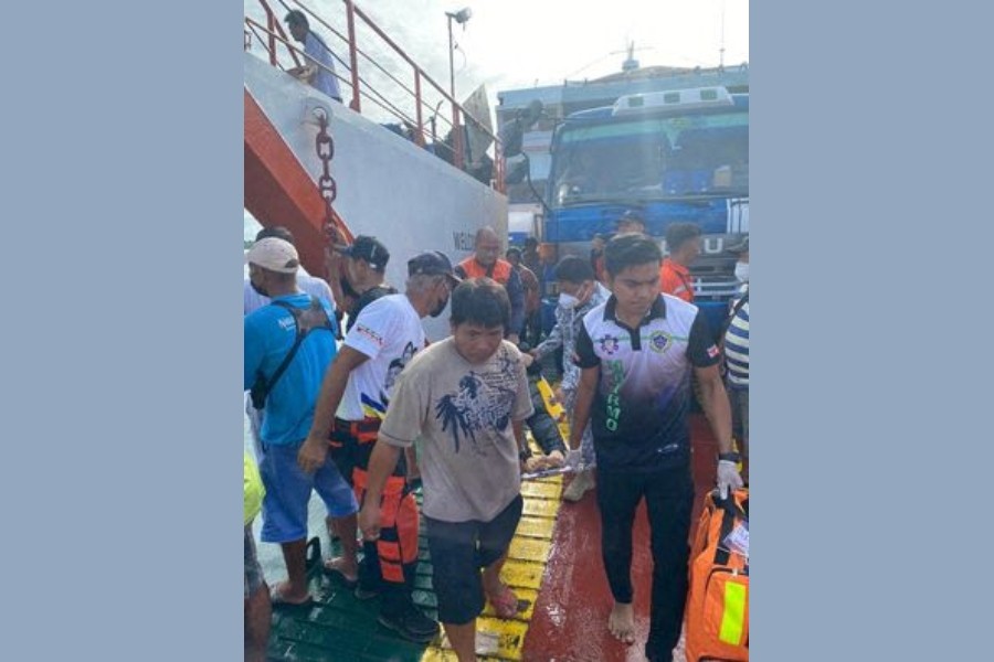 Rescuers carry a rescued passenger after a passenger vessel carrying more than 100 people caught fire near Real, Quezon province, May 23, 2022. Philippine Coast Guard/Handout via REUTERS