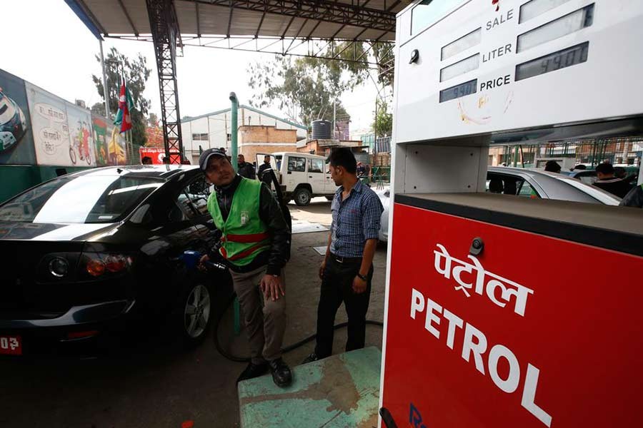 A petrol pump attendant (L) filling petrol on a car at Saja Petrol pump in Kathmandu of Nepal –Reuters file photo