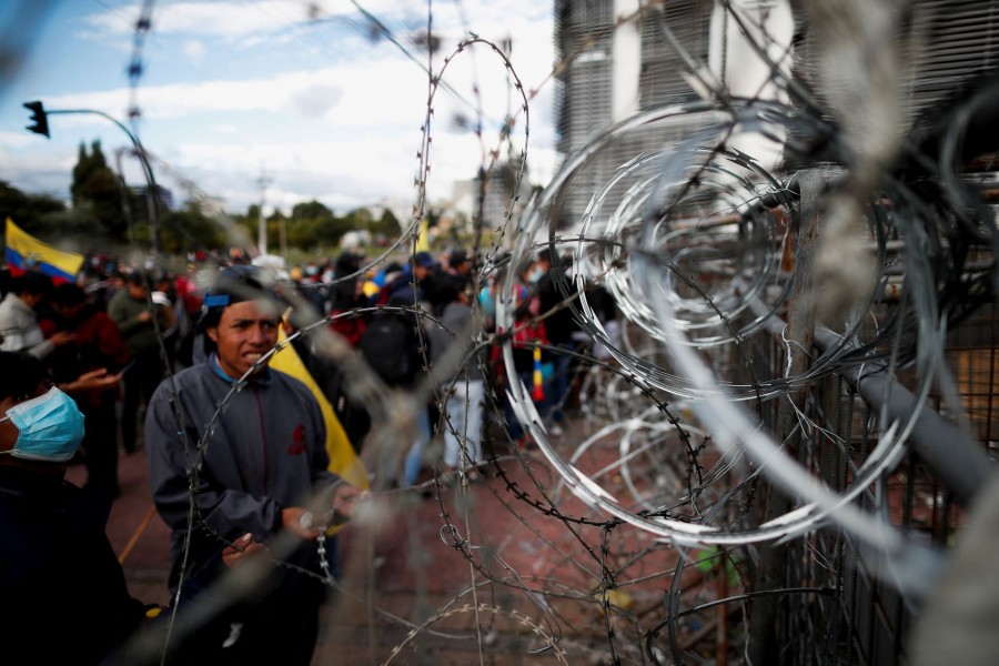 Demonstrators look at a barricade covered in barbed wire as protests continue amid a stalemate between the government of President Guillermo Lasso and largely indigenous demonstrators who demand an end to emergency measures, in Quito, Ecuador June 26, 2022. REUTERS/Adriano Machado