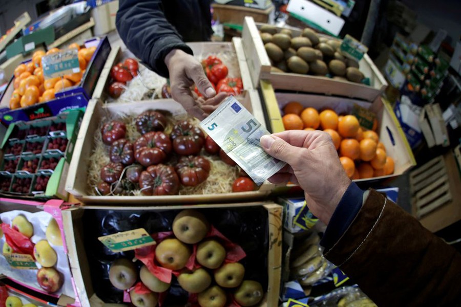 A shopper pays with a euro bank note in a market in Nice, France. 	—Reuters Photo