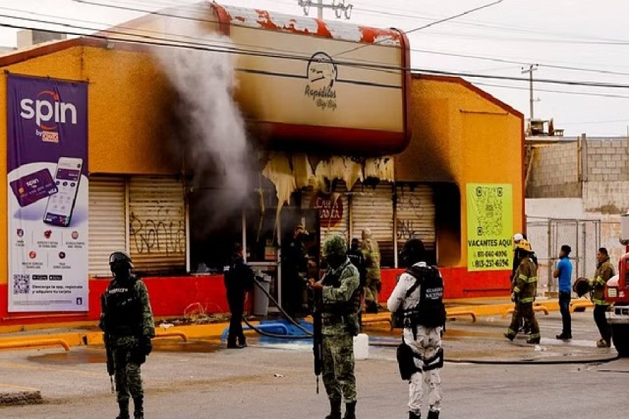FILE PHOTO: Security forces stand outside a convenience store that was burned by unknown attackers, in a simultaneous attack of fires in different parts of the city, according to local media, in Ciudad Juarez, Mexico, Aug 11, 2022. REUTERS