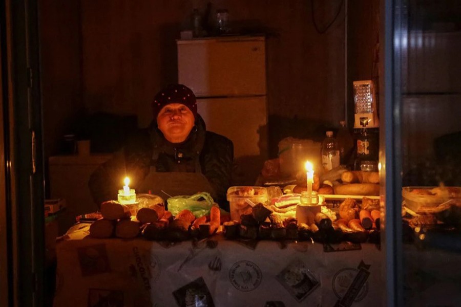 A vendor waits for customers in a small store that is lit with candles during a power outage after critical civil infrastructure was hit by Russian missile attacks, as Russia's invasion of Ukraine continues, in Odesa, Ukraine on December 5, 2022 — Reuters photo