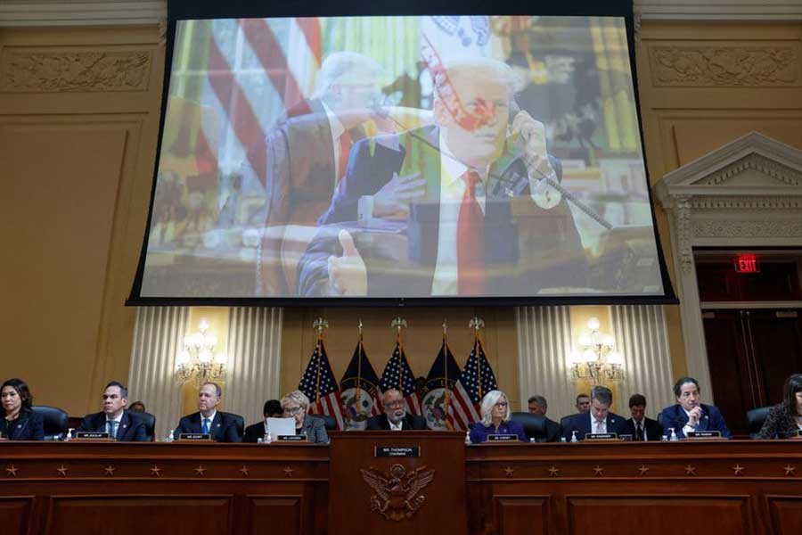 The members of the US House Select Committee investigating the January 6 Attack on the US Capitol sit beneath two overlapping images in a video showing former President Donald Trump speaking on the telephone in the Oval Office as they hold their final public meeting to release their report on Capitol Hill in Washington on December 19 this year –Reuters file photo