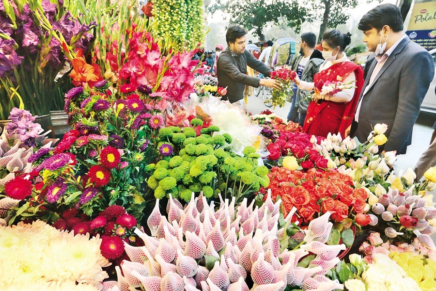 As part of their preparations to welcome New Year 2023, people are buying flowers at a shop in the capital's Shahbagh flower market on Saturday. — FE Photo by KAZ Sumon