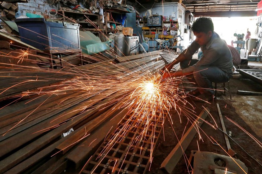 A worker grinds a metal gate inside a household furniture manufacturing factory in Ahmedabad, India on July 1, 2016 — Reuters/Files