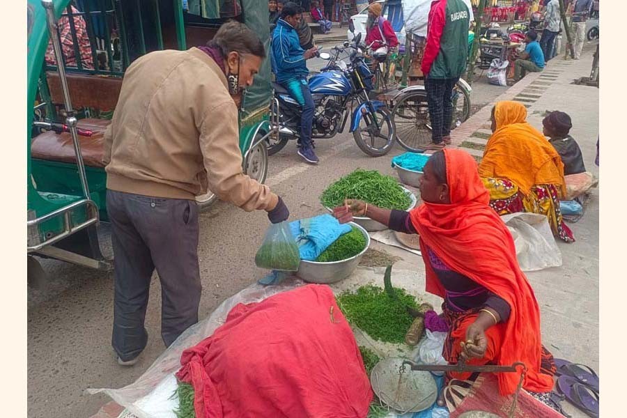 A customer buying washed and chopped grass pea greens from Champa Begum at the C & B intersection in Rajshahi city — FE Photo
